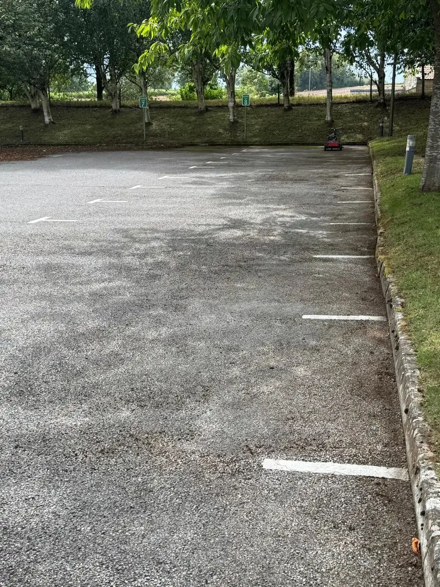Clean car park surface and grass edge after moss clearance
